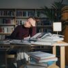 Frau sitzt verzweigfelt an einem Schreibtisch