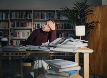 Frau sitzt verzweigfelt an einem Schreibtisch